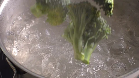 Broccoli fall into a boiling pot of water. Slow motion Видео 105346193