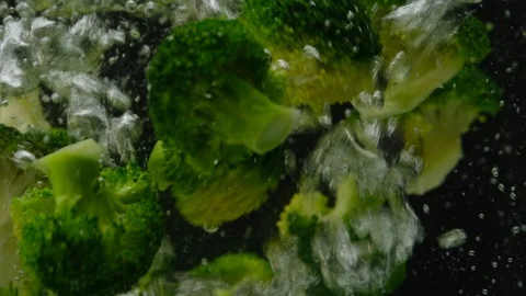 Broccoli falling in boiling water. black background Stock-Footage 121394944