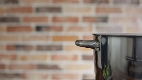 Broccoli falling down into saucepan with boiling water Stock Footage 102704412