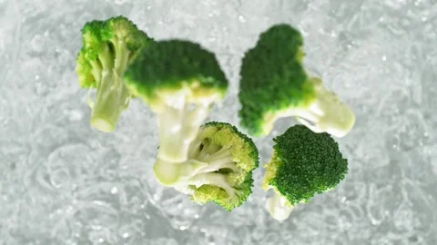 Broccoli Florets Falling into Pot of Boiling Water Making a Splash Stock Footage 271397625