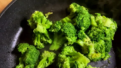 Broccoli in a frying pan while stewing. Video stock 265796823