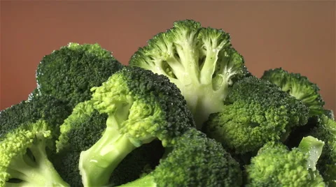 Broccoli isolated rotating on brown/orange background Stock Footage 62375854