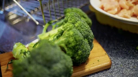 Broccoli on a kitchen counter, while cooking in the background Stock Footage 85064701