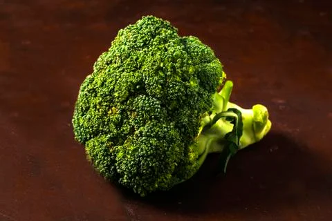 A broccoli plant on a red table. Foto stock