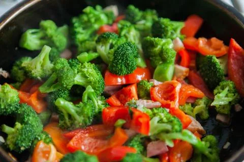 Broccoli, stewed, roasted, in a pan, pepper, smoked bacon Stock Photos