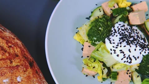 Broccoli tofu cucumber salad with dressing and baked toast on kitchen counter Stock Footage 342864621
