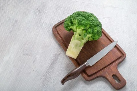 Broccoli vegetable in cutting board has knife on white background healthy e.. Stock Photos