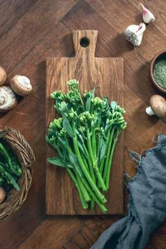 Broccolini fresh bunch on a rustic cutting board ready for cooking Stock Photos