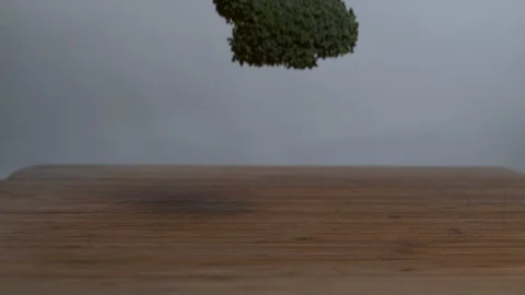 Broccolis falling on chopping board in slow motion Stock Footage 100007029