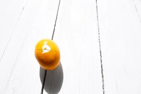 Brocken yellow easter egg on white wooden background. Happy Easter. Greetin.. Stock Photos