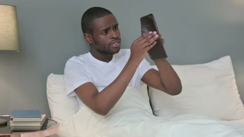 Broke Young African Man Checking Empty Wallet in Bed Stock Footage 142776350