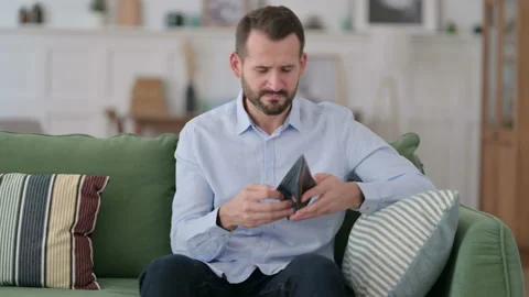 Broke Young Man Checking Empty Wallet on Sofa Stock Footage 143079552