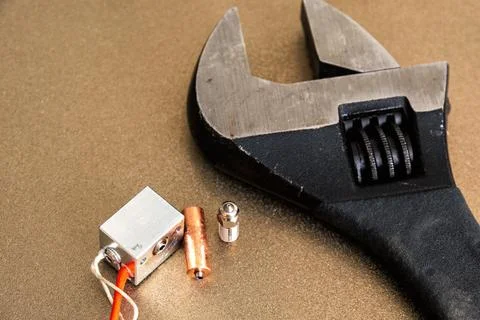 Broken 3d printer heat block and heat break and nozzle with big wrench Stock Photos