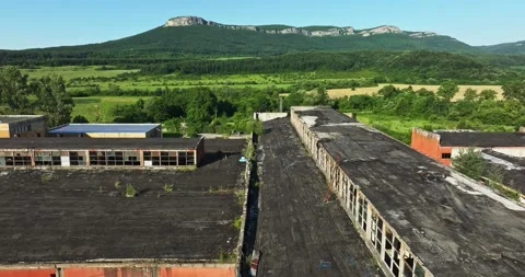 Broken In Abandoned Storage Unit Overlooking Vibrant Landscape Aerial Fpv Fly Video stock 289412835