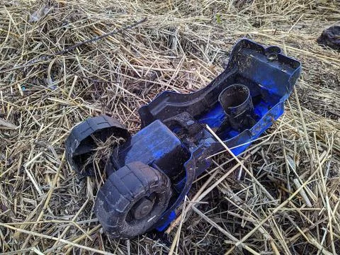 Broken and big blue toy car in dry grass after rain Stock-Fotos