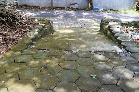 Broken and uneven stone pathway in an outdoor garden Stock Photos