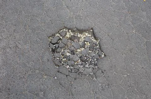 Broken asphalt and cracks on the road surface Stock Photos
