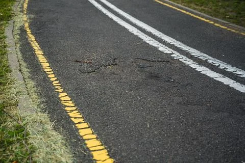 Broken asphalt on the bike path Stock Photos
