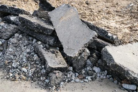 Broken asphalt slabs collected in irregular heap after road removal represent Photos