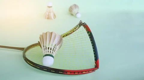 Broken badminton racket with a shuttlecock on a light green surface, endura.. Stock Photos