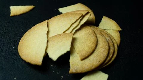 Broken baked chips crisps isolated on black background Stock Photos