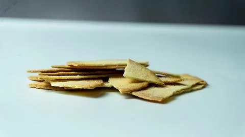 Broken baked chips crisps on a white table background Stock Photos