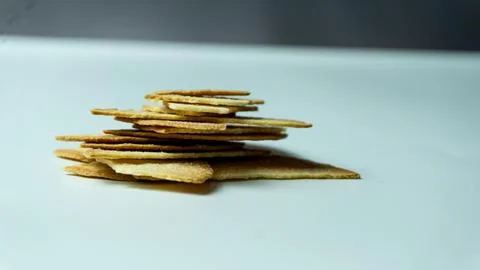 Broken baked chips crisps on a white table background Stock Photos