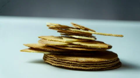 Broken baked chips crisps on a white table background Stock Photos