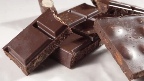 Broken bar of dark chocolate with almonds Stock Footage 133775560