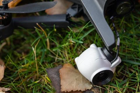 Broken black quadcopter drone uav lying on green grass lawn on ground after.. Stock-Fotos