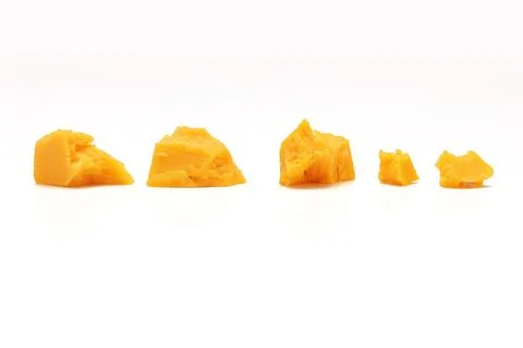 Broken Block of Orange Cheddar Cheese assorted chunks pieces bits Stock Photos