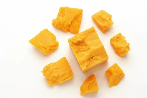 Broken Block of Orange Cheddar Cheese assorted chunks pieces bits Stock Photos