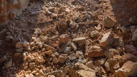 Broken brick on the ground is lit by a ray of the sun. Camera movement. Stock Footage 128412601