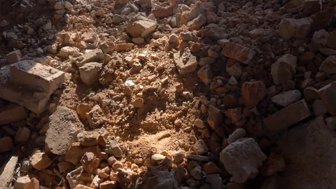 Broken brick on the ground is lit by a ray of the sun. Camera movement. Stock Footage 128412658