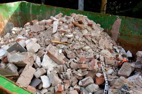 Broken bricks in a dumpster on a construction site Stock Photos