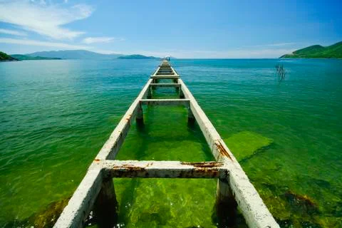Broken bridge to the emerald sea Stock Photos
