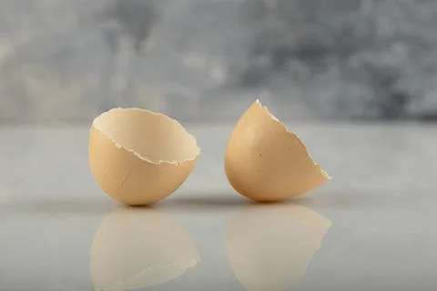 Broken brown eggshell on a marble background Stock Photos