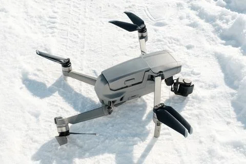 Broken camera and drone arm after crash on snow in winter Stock Photos