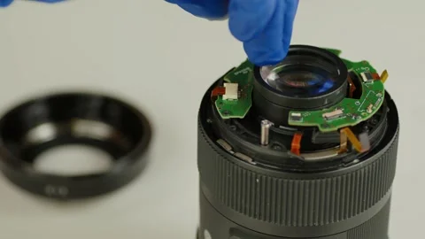 Broken camera lens. Close up. Unrecognizable person in gloves unscrews bolt with Stock Footage 187423885