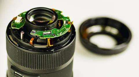 Broken camera lens on white background. Close up. Concept of repair of photog Stock Photos