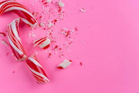 Broken candy cane on pink background. close-up photo Stock Photos