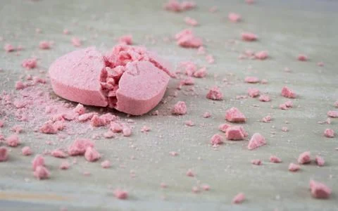 Broken Candy Heart with Crushed Candy Bits Strewn Around Stockfoto's