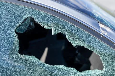 Broken car window with hole and shattered glass pattern. Broken car damage Foto stock