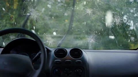 A broken car windshield and falling hail during a natural disaster storm Stock Footage 220083176