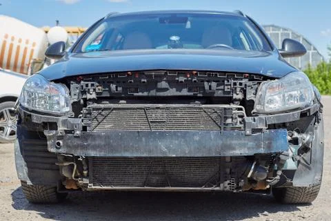 Broken car without a bumper close up in front, with an open radiator and head Stock Photos