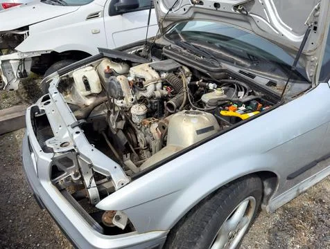 Broken car wreck with rusty engine on recycling yard Foto stock