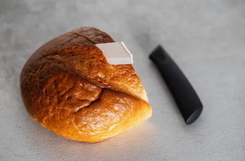 A broken ceramic knife lies on the table next to the loaf. Poor quality ceramic Stockfoto's