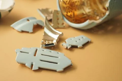 Broken ceramic pieces scattered on the table Stock Photos