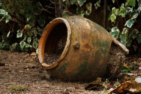 Broken ceramic pot with soil inside decorating the garden of a house Stock Photos