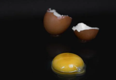 Broken chicken egg on black background close up Stock Photos